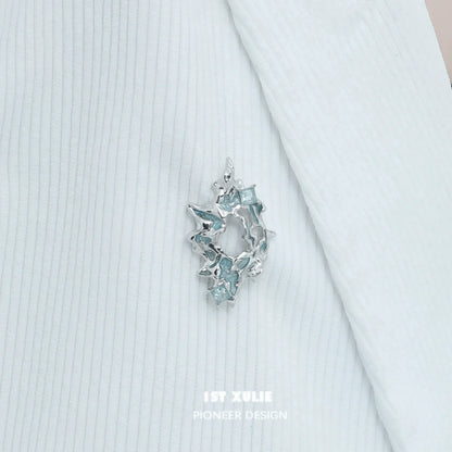 Elegant silver statement brooch featuring sparkling blue accents for stylish decor