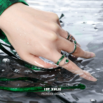 Slytherin inspired green snake ring on a hand submerged in water with a stylish green outfit