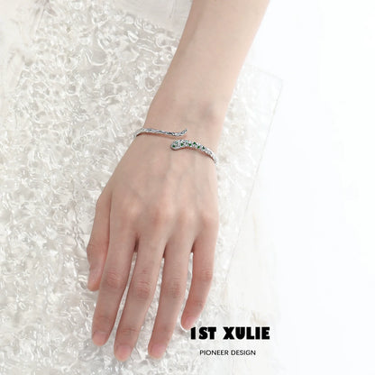 Slytherin snake silver bracelet on a hand showcasing its elegant design and green accents.