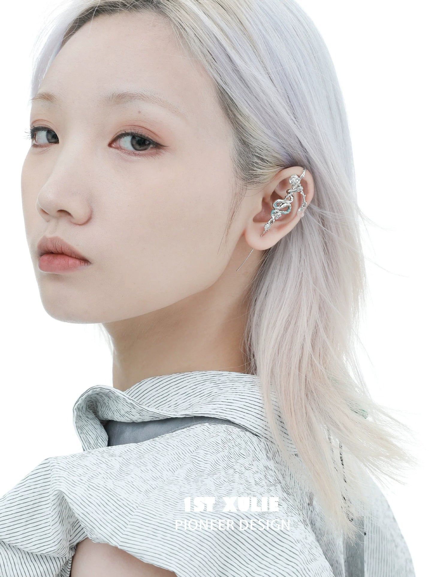 Elegant snake ear piercing jewelry showcased on model with silver hair and minimalist fashion