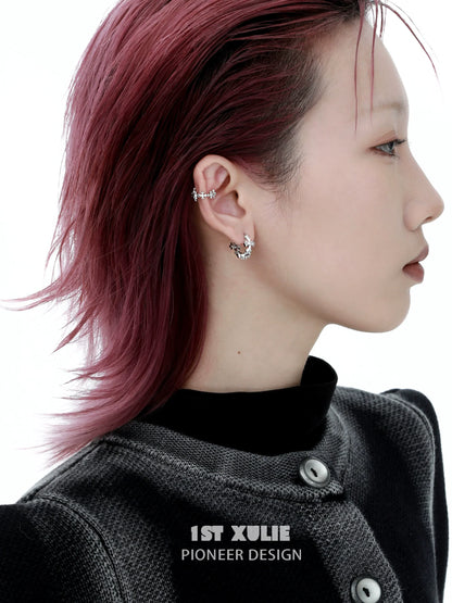 Stylish model wearing spiked cross earrings with a modern design for a bold look