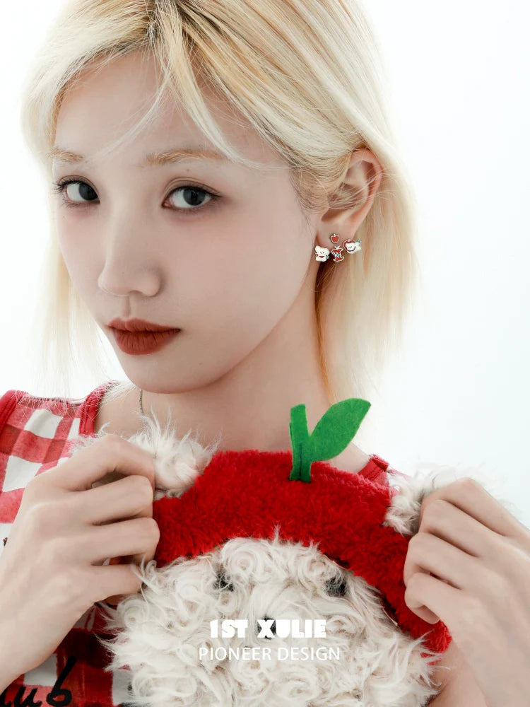 Model wearing sweet apple pet removable earrings while holding a plush apple toy