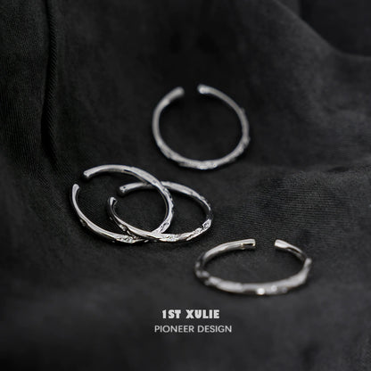 Set of four elegant textured silver rings with unique designs, perfect for stacking or solo wear
