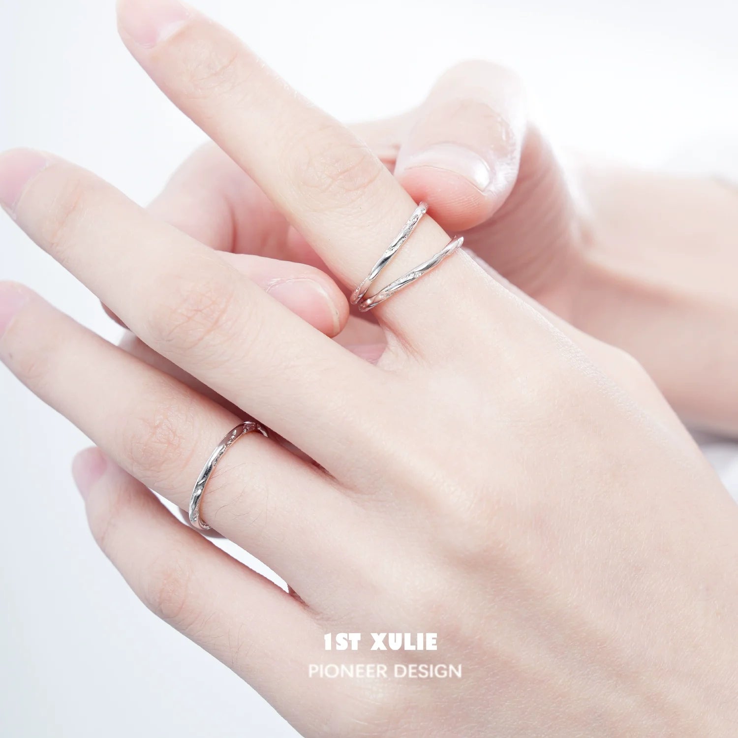 Set of textured silver rings stacked on fingers showcasing elegant design by 1ST XULIE