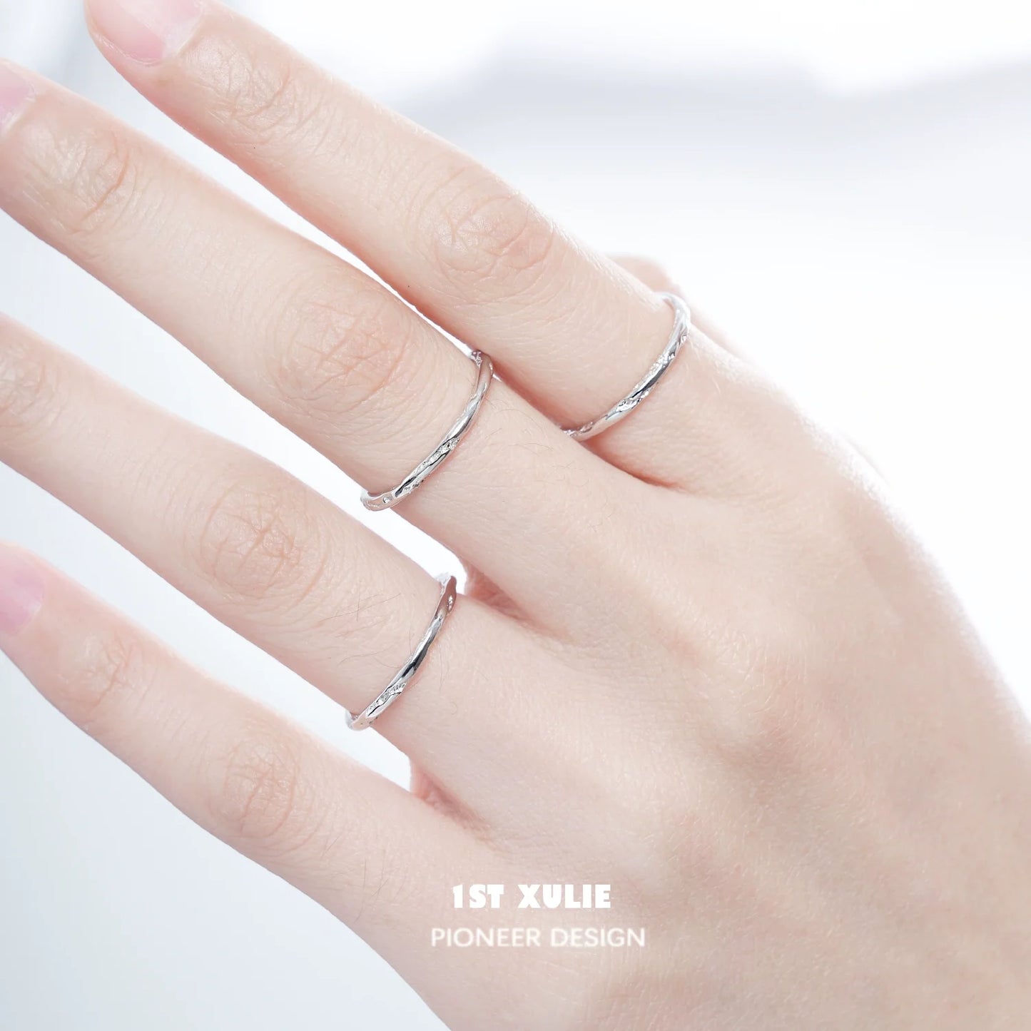 Set of three textured silver rings stacked on a model's hand for stylish jewelry layering