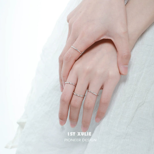 Set of textured silver rings worn on fingers for a stylish and elegant look