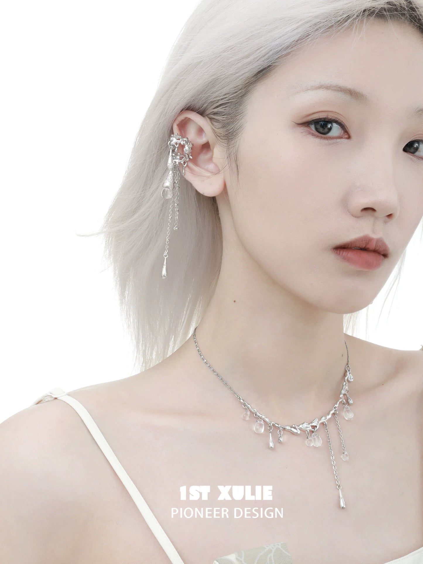 Model wearing 1ST XULIE tidal wave ear cuffs with elegant silver detailing and sparkling charms