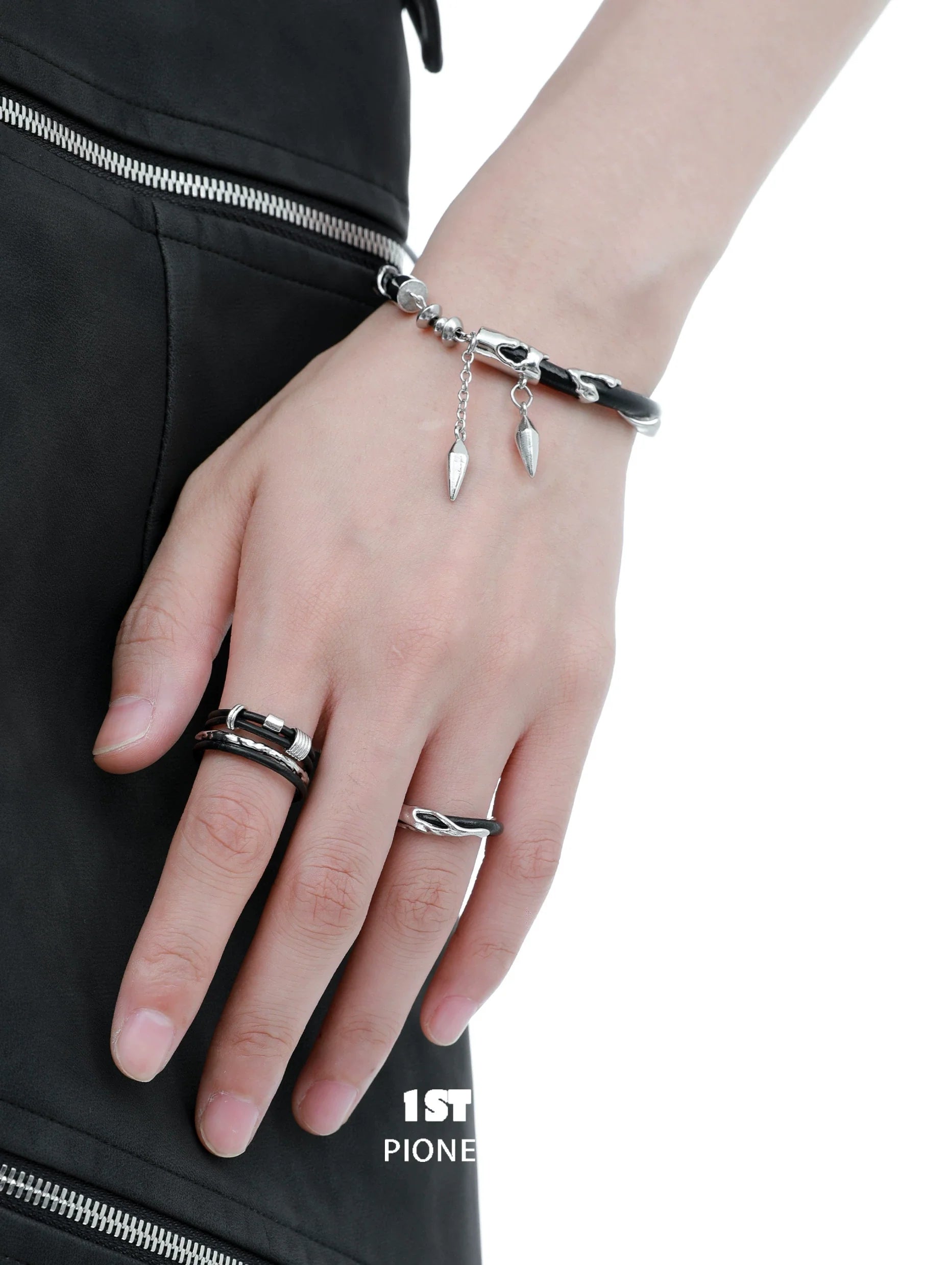 Y2K black chain leather bracelet with silver charms worn on a model's hand