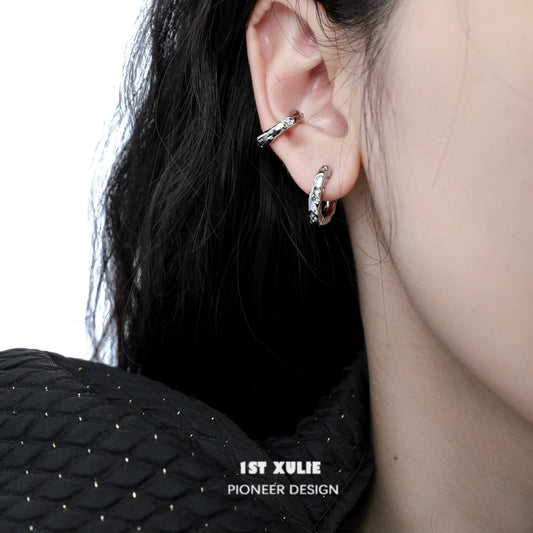 Close-up of a model wearing a Y2K frosted ear cuff in silver with a unique twisted design