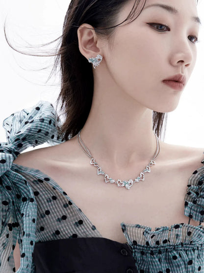 Y2K melting love earrings in silver, complemented by matching jewelry on a model
