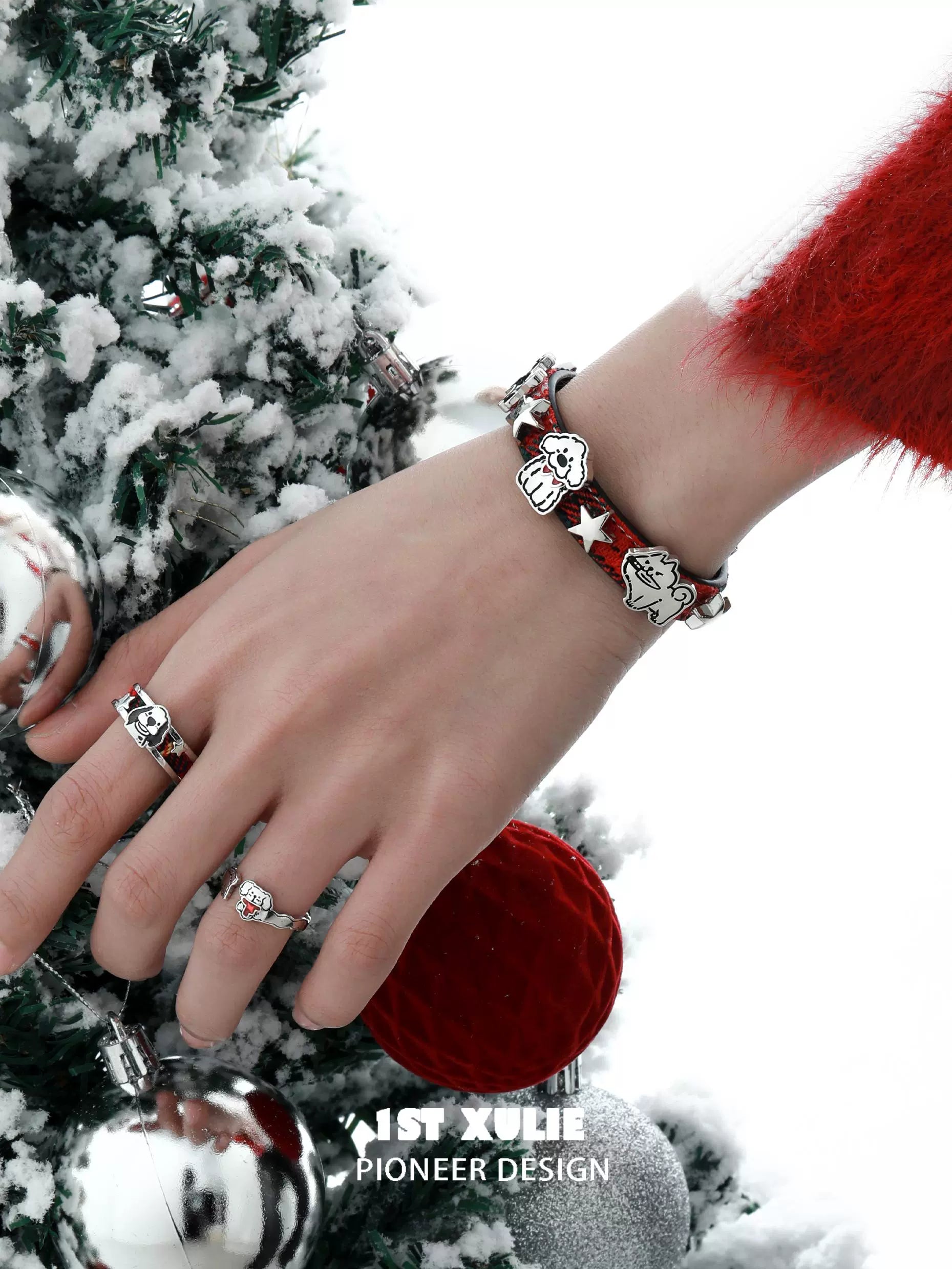 Y2K puppy bracelet with colorful charms worn on a hand near a decorated Christmas tree