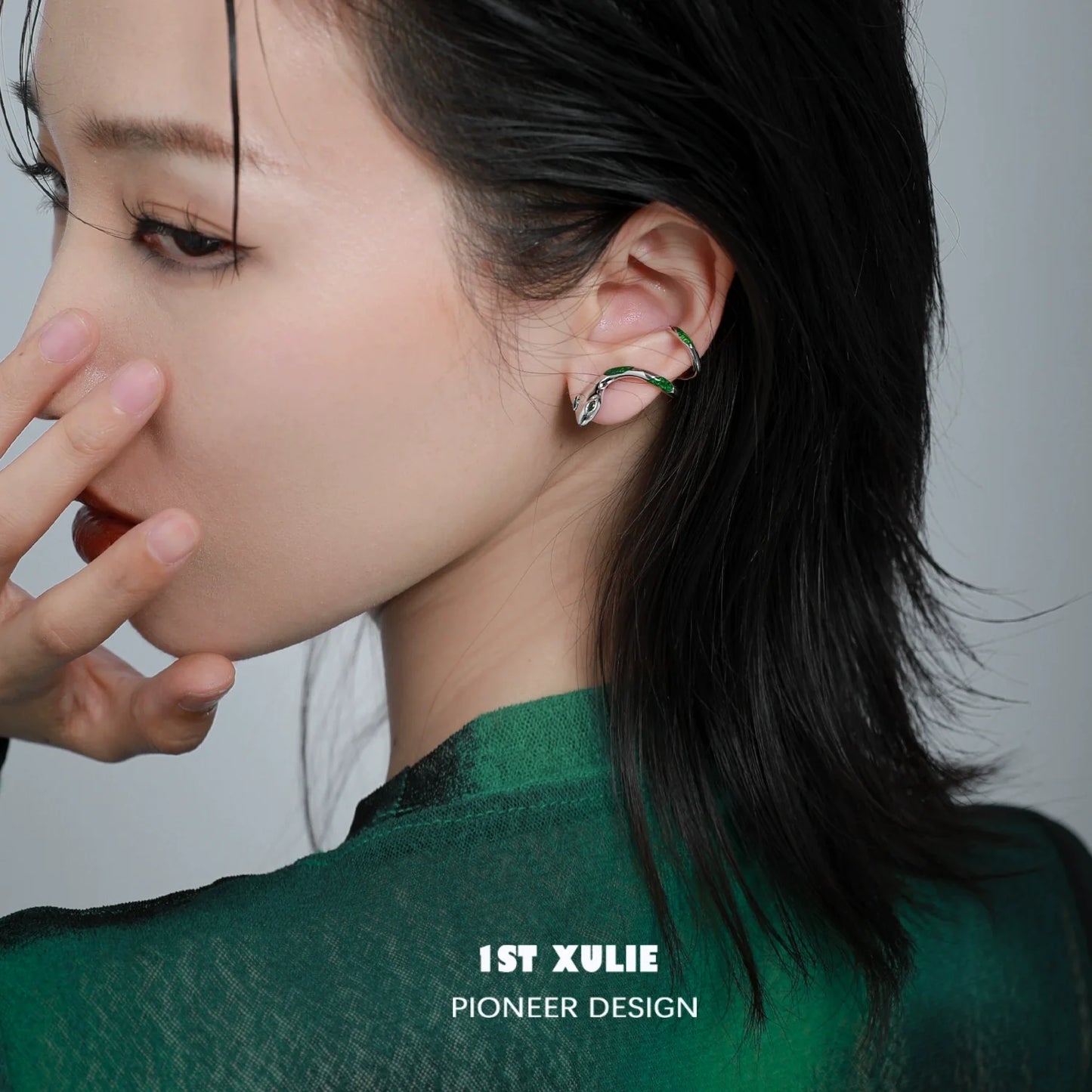 Y2K Slytherin snake earrings showcased on a model with dark hair and a green outfit