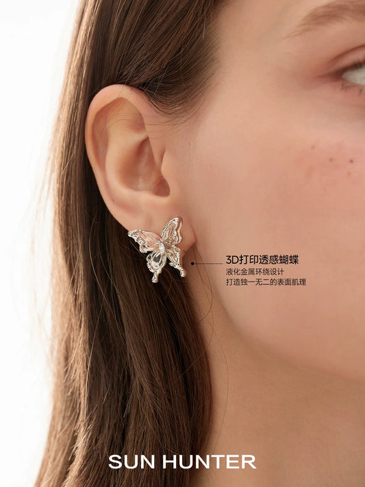 Elegant SUN HUNTER 3D butterfly earrings shining in silver, perfect for stylish accessorizing