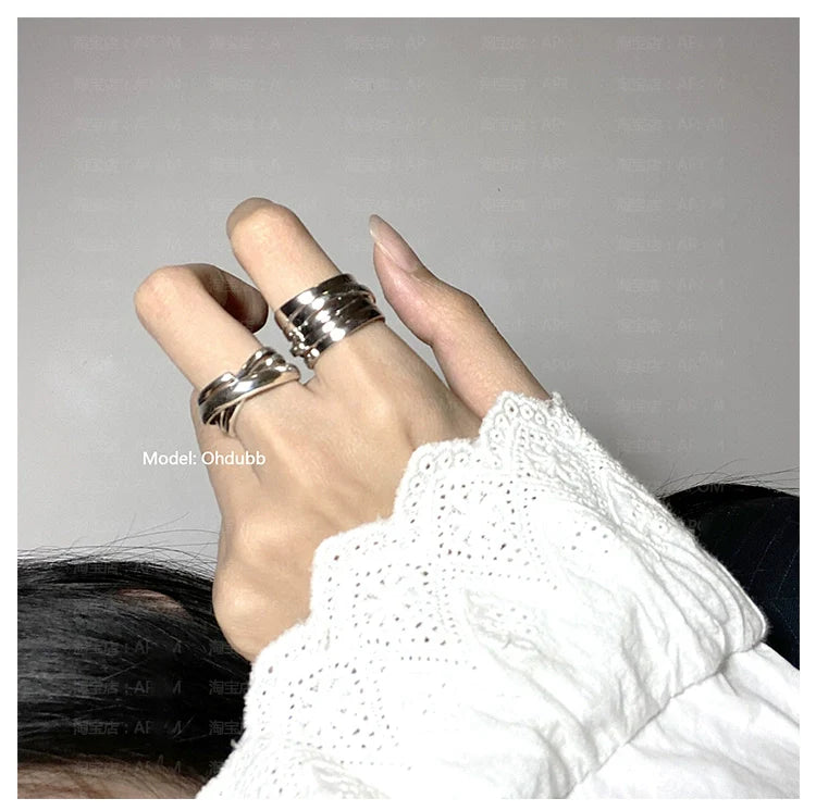 Stylish hand wearing multiple silver rings including a bandage wrap punk ring for a trendy look