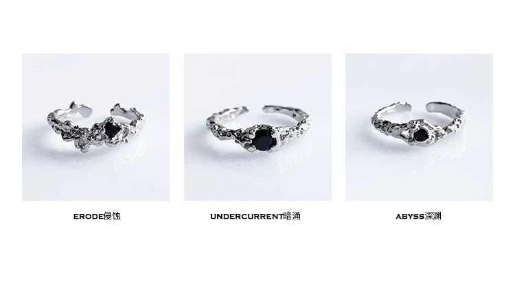 A black crown ring featuring intricate detailing and a central black gemstone for a unique style