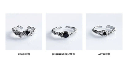 A black crown ring featuring intricate detailing and a central black gemstone for a unique style