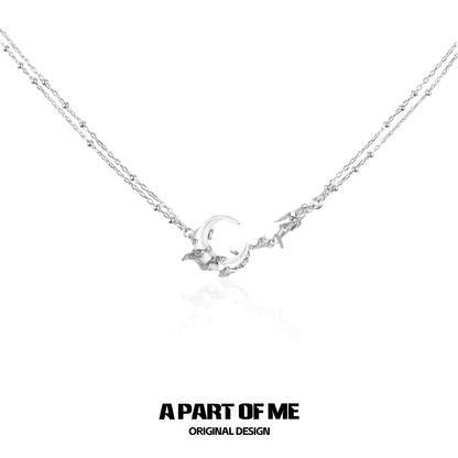 Delicate silver crescent moon necklace with intertwining chains for elegant layering