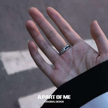 Elegant dark hills ring displayed on a hand against a street backdrop