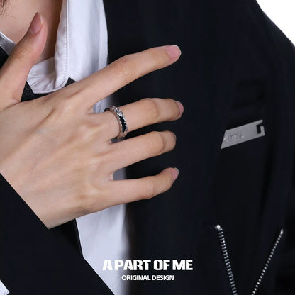 Stylish dark hills ring worn on a hand, complementing a modern outfit with a sleek design