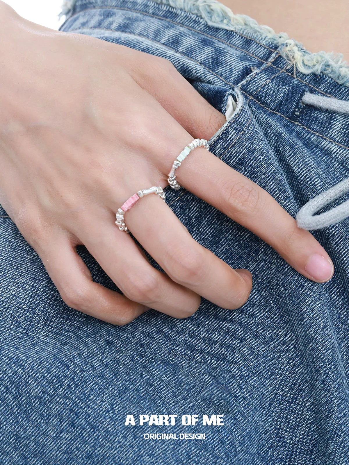 Two A PART OF ME dopamine rings stacked on a hand with denim shorts for a trendy look