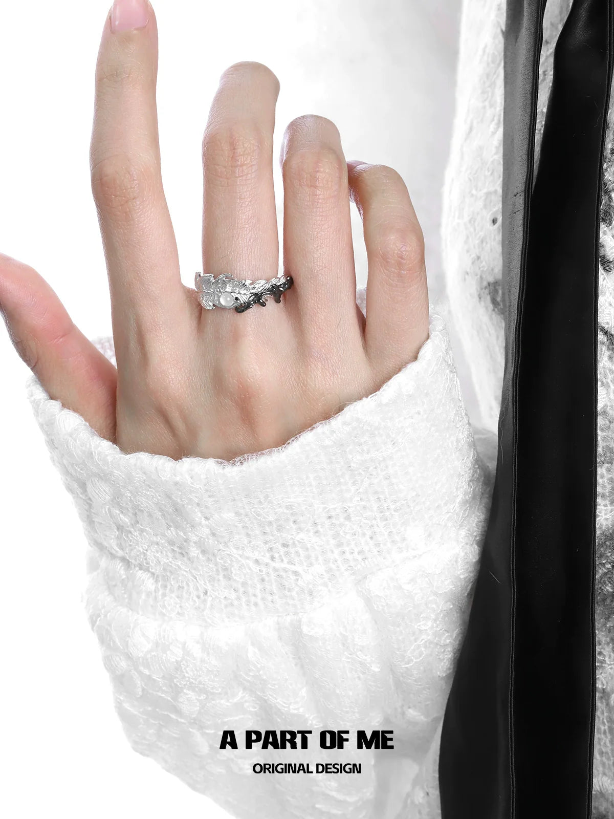A PART OF ME feather letter ring displayed on a model's hand with a cozy white sweater