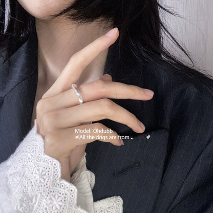 Silver geometric star ring worn elegantly on a model's hand with a stylish outfit