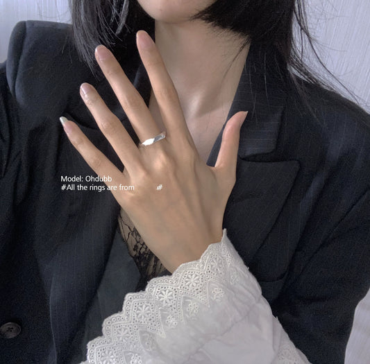 Stylish silver geometric star ring worn on a model's hand with a chic outfit
