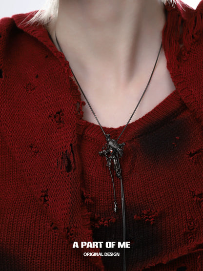 Gothic crow cross necklace displayed on a model wearing a distressed red sweater