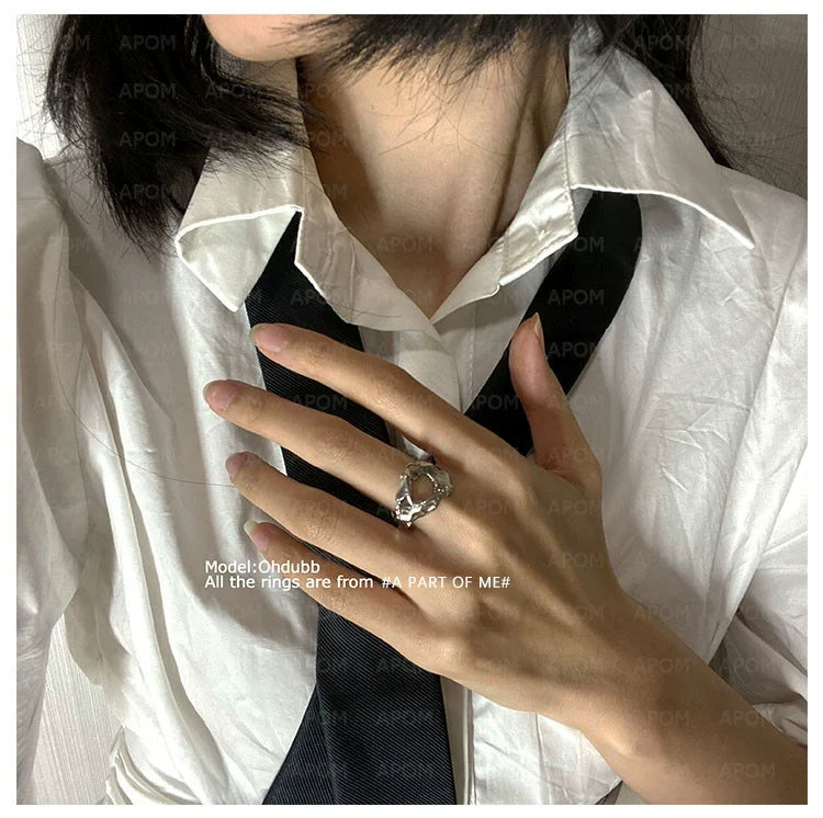 Model wearing an A PART OF ME imperfect beauty silver ring on a hand with a black tie and white shirt
