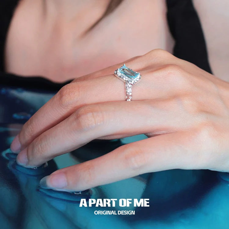 Elegant A PART OF ME mermaid tears silver ring with a sparkling blue gemstone, worn on a hand