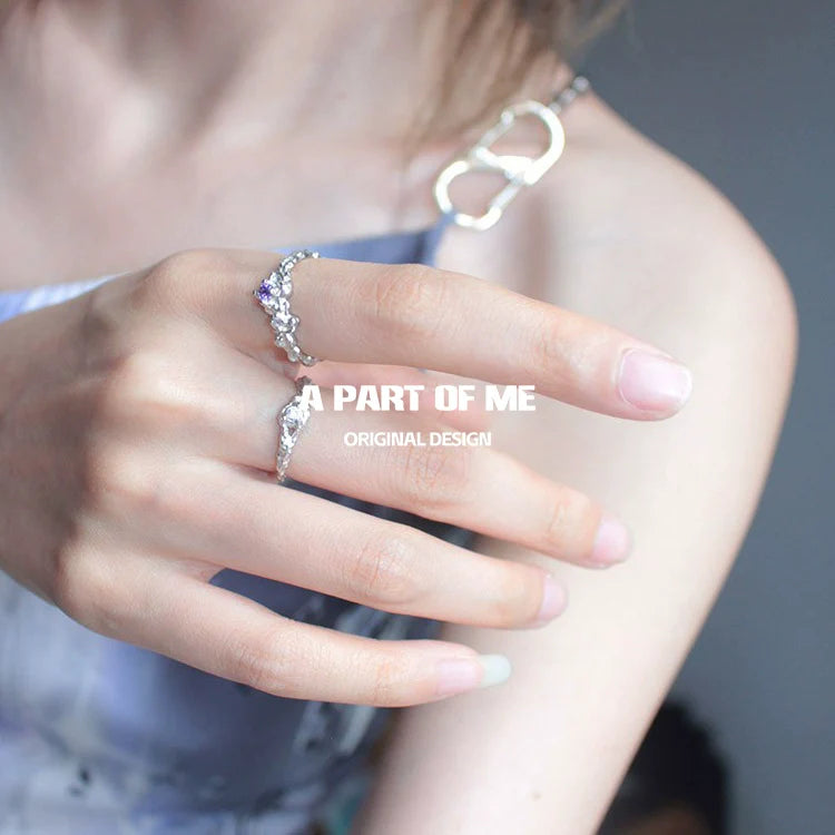 Stylish purple zircon wave ring on hand showcasing elegant design and sparkle