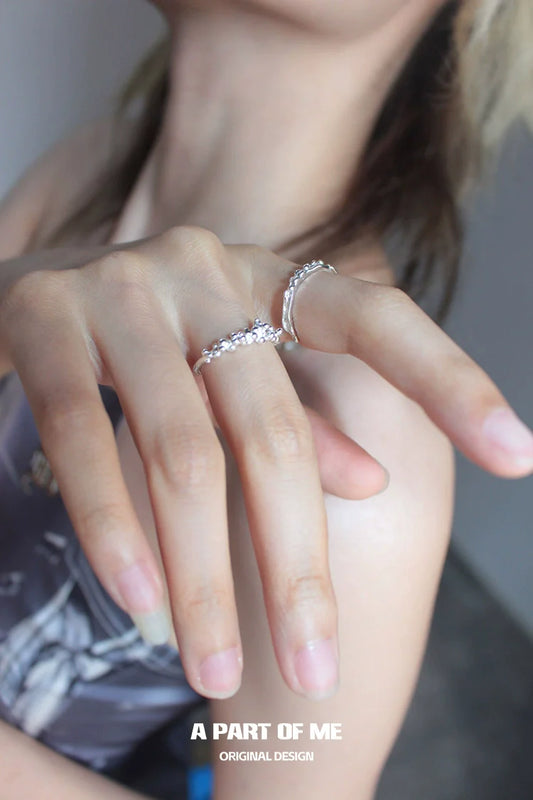 Silver surf texture couple rings elegantly worn on a hand showcasing their unique design