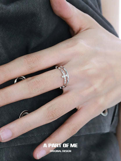 Textured cross silver ring worn on a model's finger showcasing unique design and craftsmanship