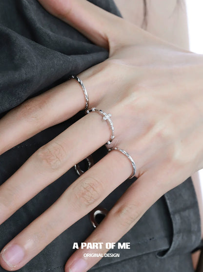 Two textured cross silver rings from A PART OF ME worn on a model's hand showcasing a stylish design