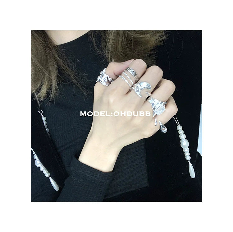Stylish hand adorned with textured silver rings showcasing elegant design and intricate details