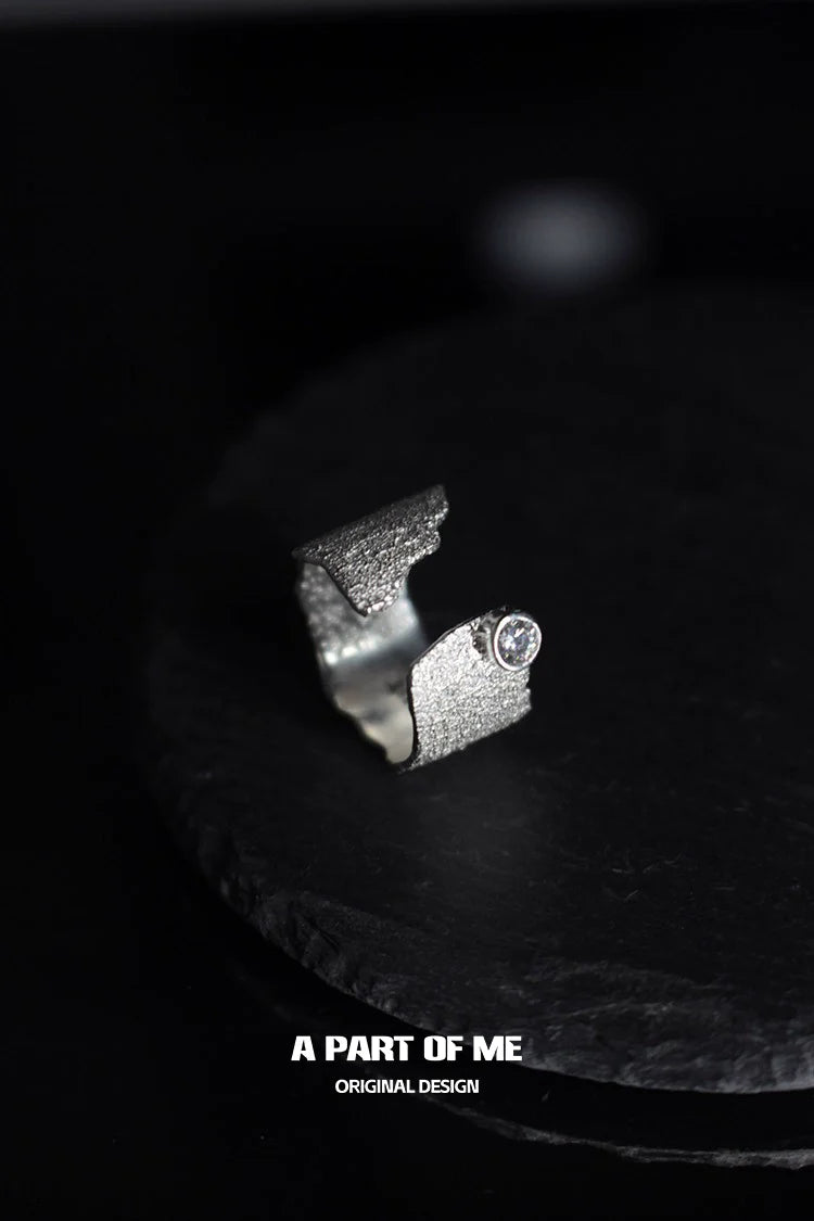 Textured silver travel ring with a unique design featuring a sparkling stone