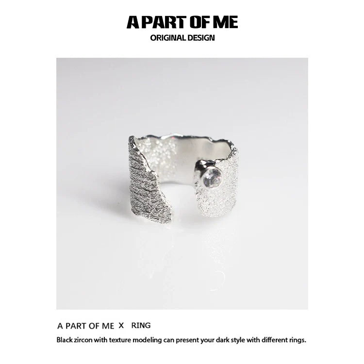 Textured silver travel ring from A PART OF ME showcasing a unique design with black zircon accents