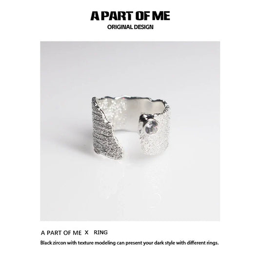 Textured silver travel ring from A PART OF ME showcasing a unique design with black zircon accents