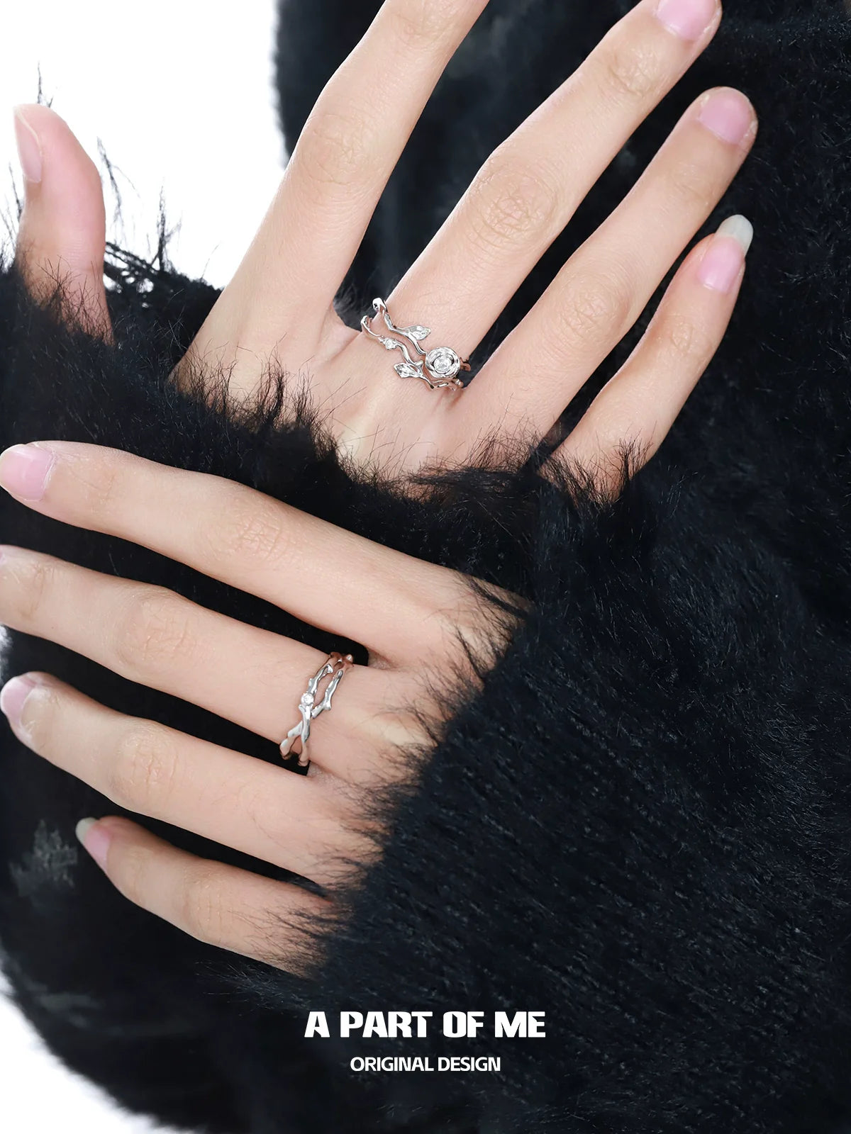 A PART OF ME thorned rose silver ring displayed on a model's fingers with stylish black fur textures