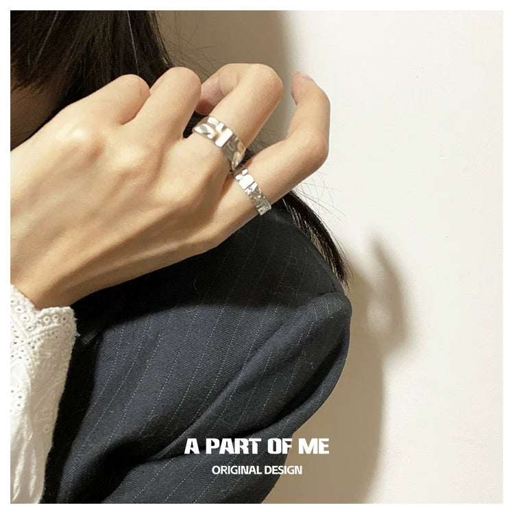 Stylish silver tinfoil crinkle punk ring worn on a hand with a black outfit