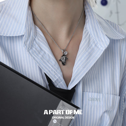 Sterling silver working puppy necklace worn with a button-up shirt, showcasing an elegant design