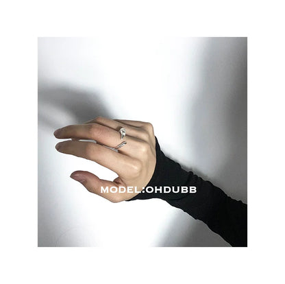 Y2K silver statement ring worn on hand with a black long-sleeve shirt for a trendy look