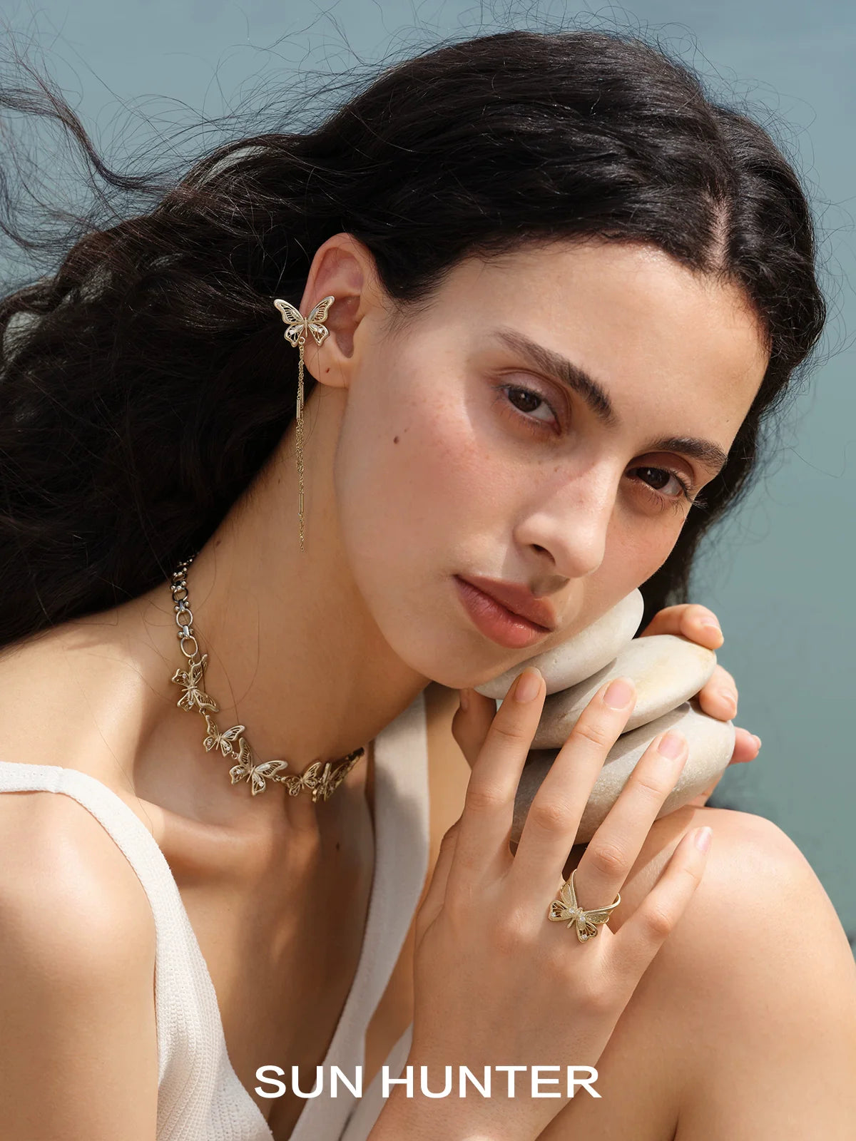 SUN HUNTER angel butterfly ring showcased with elegant jewelry against a serene background