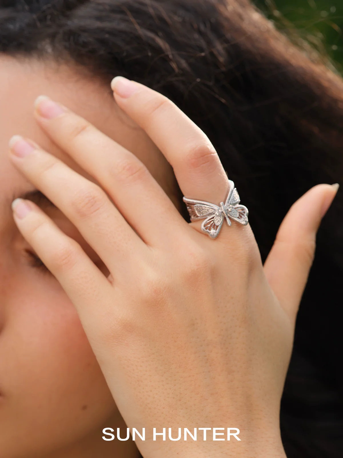 Elegant SUN HUNTER angel butterfly ring displayed on a model's hand, showcasing its intricate design