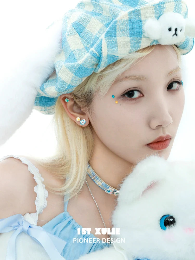 Angel cat paw print earrings styled with a blue checkered hat and soft plush toy