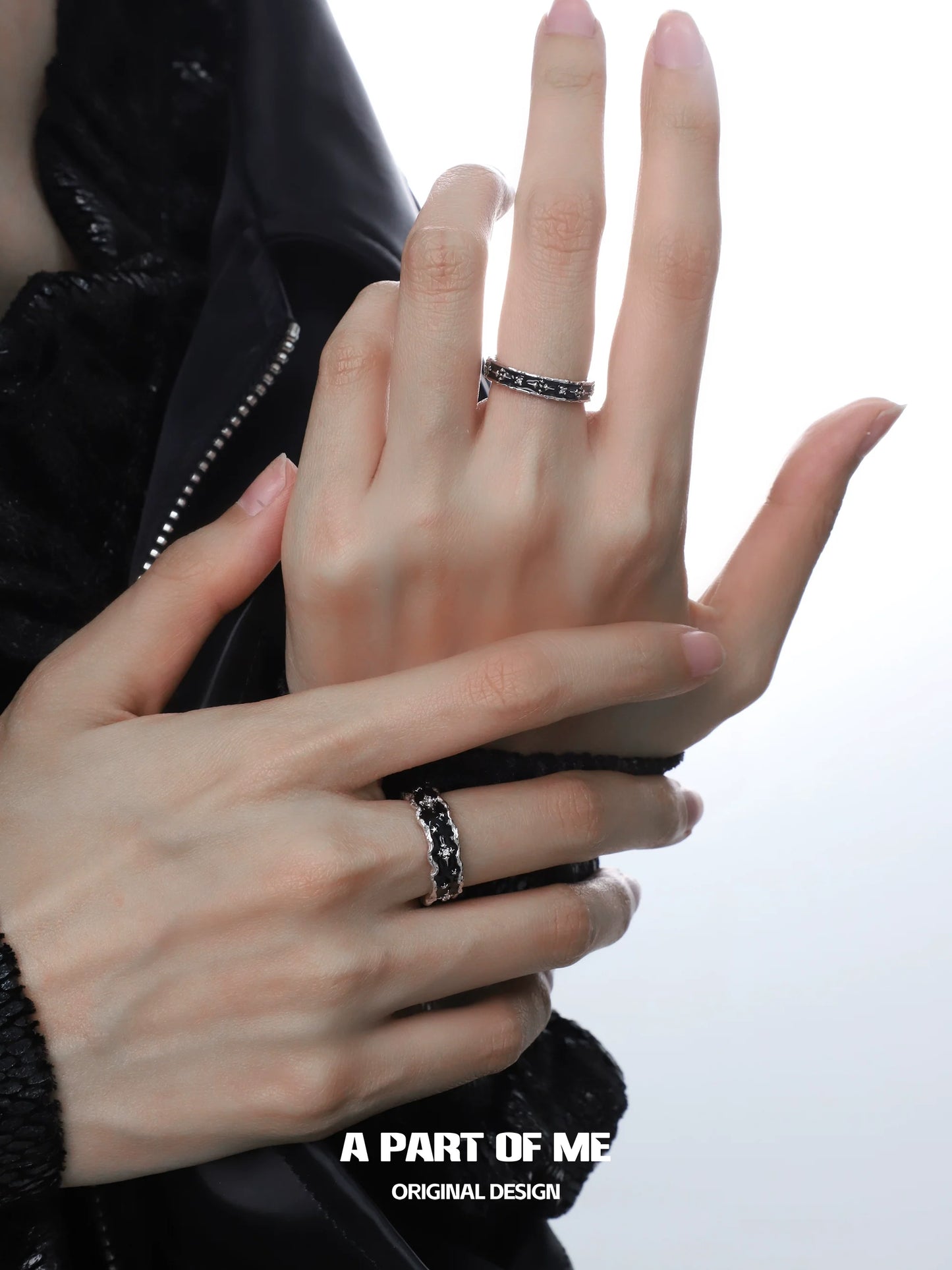 A stunning black star cluster ring showcased on a model's hand among silver rings for elegant styling