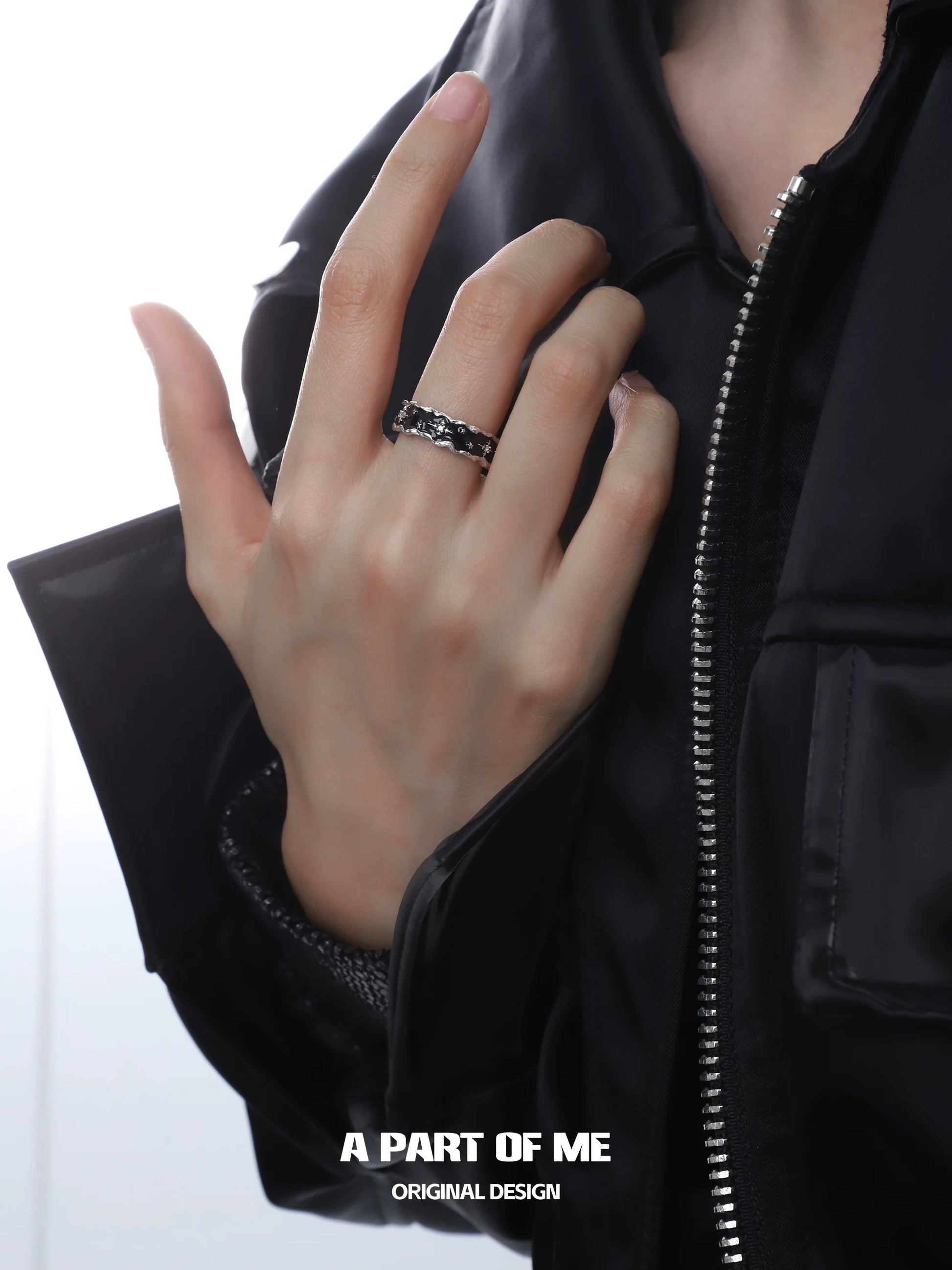 A Part of Me black star cluster ring shown on a model's hand with stylish outfit
