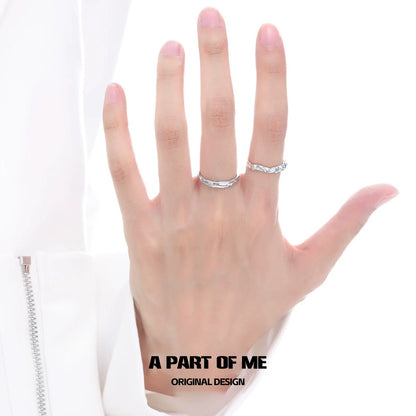 A hand wearing a blue slim statement ring alongside a silver band for stylish accessorizing