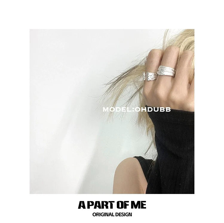 A PART OF ME cliff crack silver ring displayed on a model's hand with stylish outfit