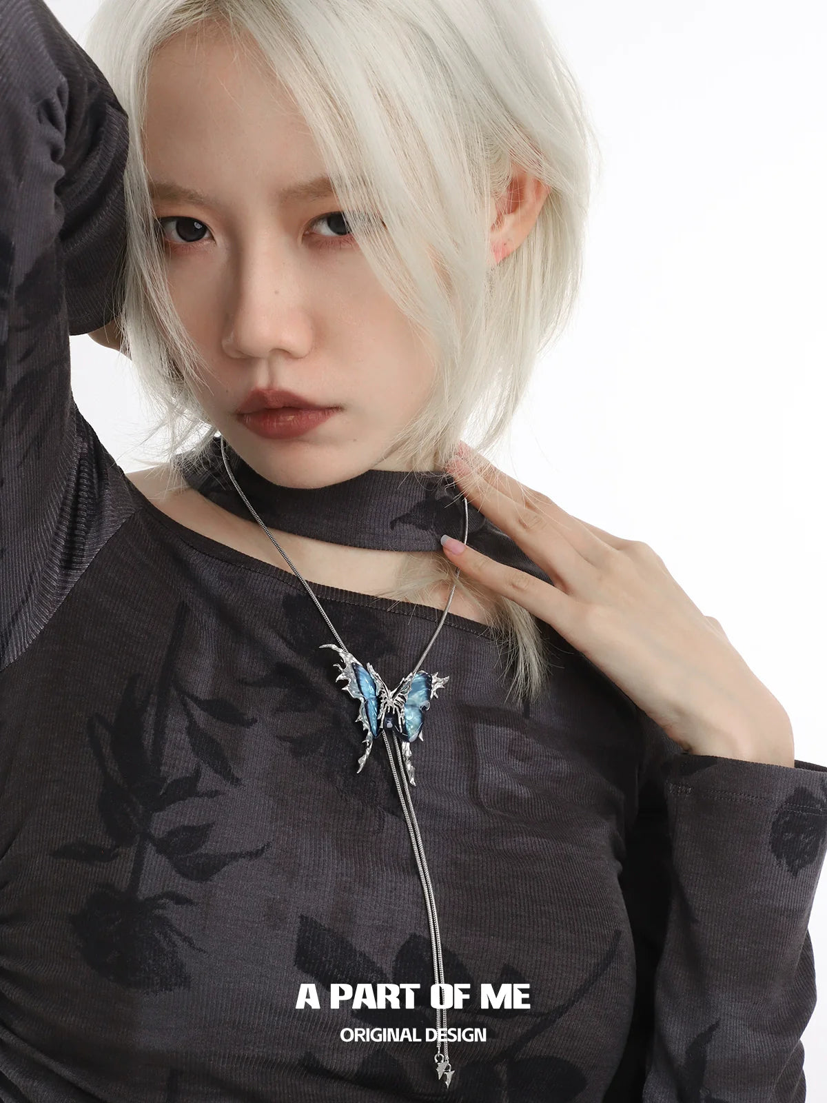 Colored butterfly necklace featuring intricate design and vibrant colors on a model wearing a stylish top